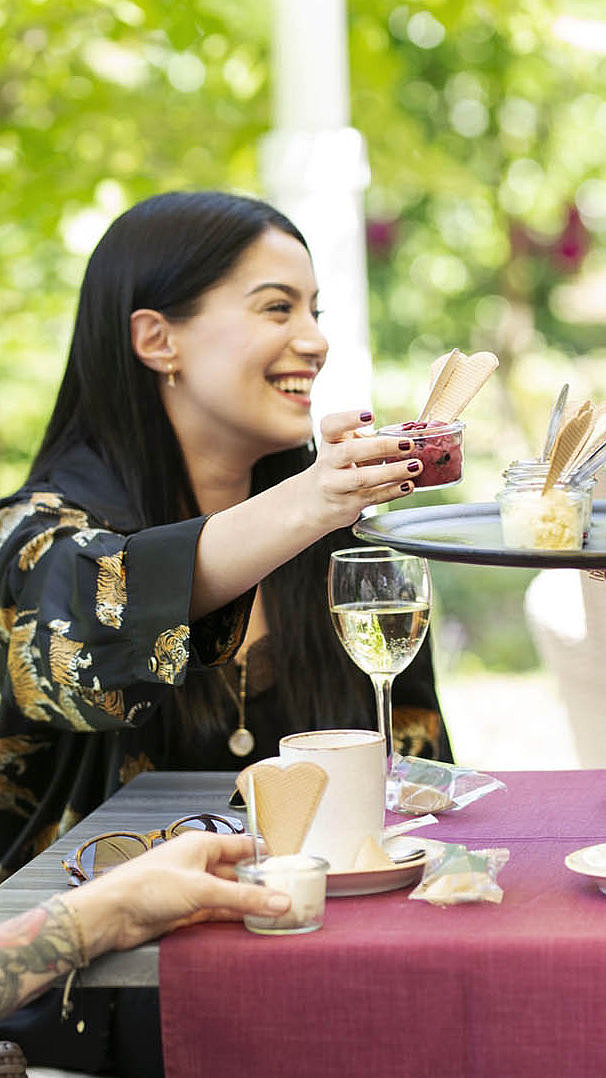 Drei Frauen auf der Hotelterrasse bekommen einen Dessert serviert